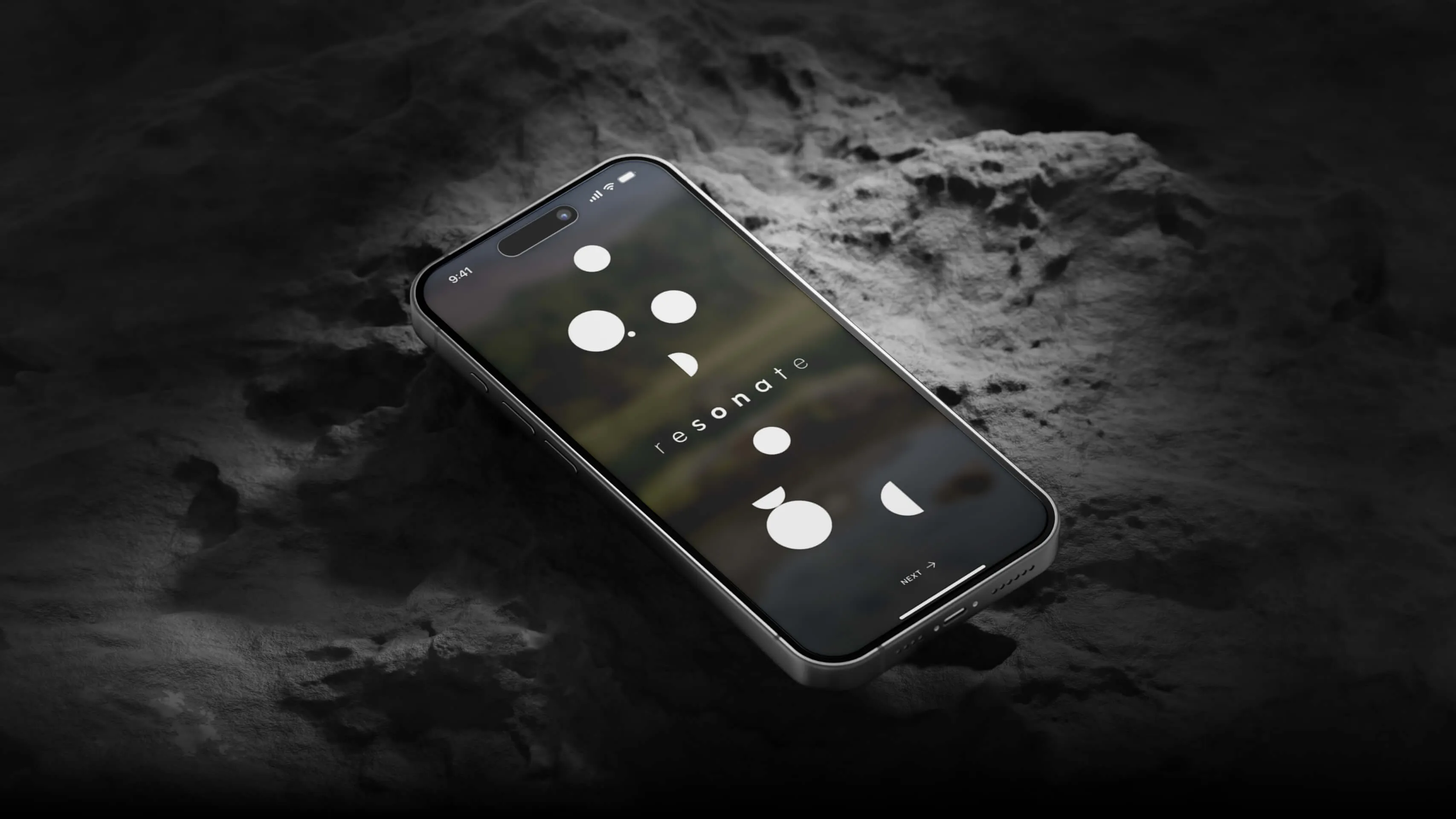 Smartphone lying at an angle on a dark, rocky surface, displaying the 'resonate' logo with minimalist geometric shapes. The modern and elegant design stands out against the mysterious and dimly lit background.